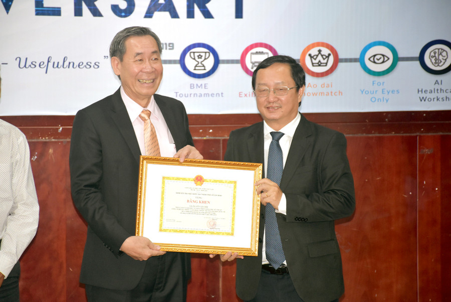 Ông Huỳnh Thành Đạt – Giám đốc ĐHQG TPHCM (phải) trao bằng khen của ĐHQG TPHCM cho GS Võ Văn Tới