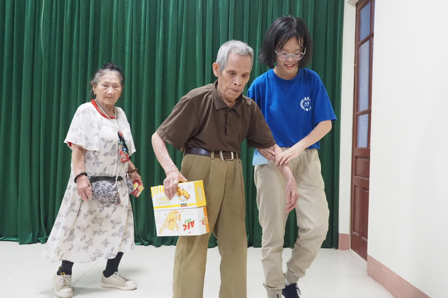 Học sinh trường THCS Mai Dịch (áo xanh) đỡ cụ ông tại buổi lễ trao quà. Học sinh trường THCS Mai Dịch (áo xanh) đỡ cụ ông tại buổi lễ trao quà.