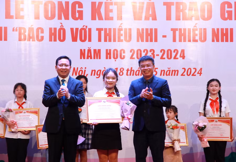 Ban tổ chức trao giấy chứng nhận cho em Nguyễn Trúc Linh, học sinh đạt giải Nhất.