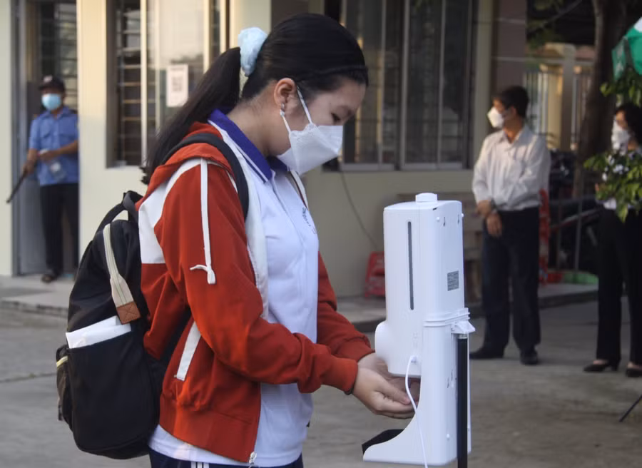 Trường THPT Lê Quý Đôn (TP.Tân An, Long An), bố trí 2 máy đo thân nhiệt kết hợp rửa tay tự động và lực lượng gồm 4 người đo thân nhiệt trực tiếp cho học sinh tại cổng trường...