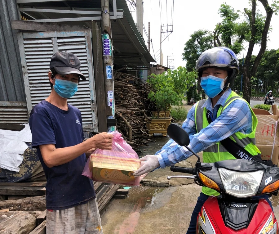 Thầy Lê Thanh Long (Trường Tiểu học Phạm Văn Hai, huyện Bình Chánh, TPHCM) giao SGK cho phụ huynh trên địa bàn huyện Bình Chánh, TPHCM.