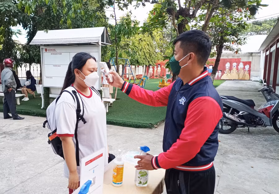 Học sinh được đo thân nhiệt và sát khuẩn tay trước khi vào trường.