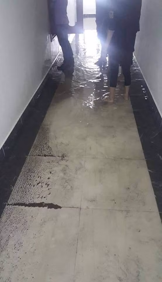 Nước ngập trên sảnh tầng 21 cao khoảng 15 -20 centimet và tràn vào các căn hộ khiến nguy cơ toàn bộ sàn gỗ của các hộ gia đình hư hỏng hết.