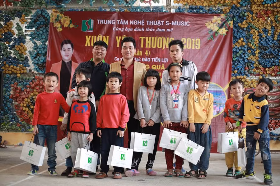 Ca sĩ Sao Mai Đào Tiến Lợi trao quà và chụp ảnh lưu niệm với các em nhỏ tại Trung tâm bảo trợ xã hội 3.