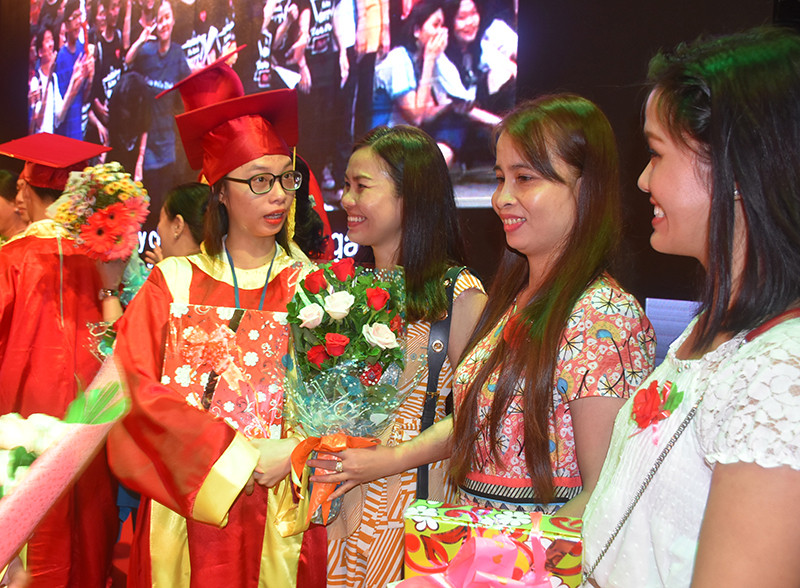 Các em HS khối 12 tặng hoa cám ơn các phụ huynh