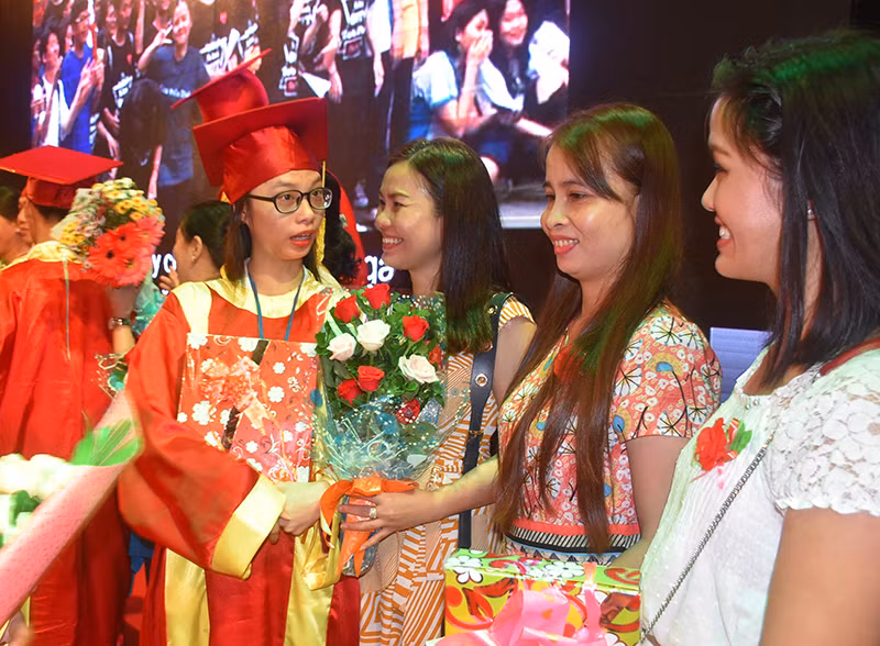 Các em HS khối 12 tặng hoa cám ơn các phụ huynh