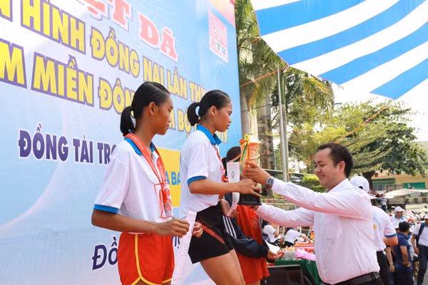 Đại diện nhãn hàng nước uống vận động Number 1 Active Chanh Muối trao cup vàng VĐV Lã Thị Tuyết Hoa (Bình Phước) giành hạng nhất nội dung 4km nữ hệ mở rộng.