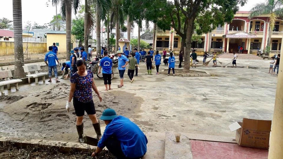 Nước đã rút hết, các thầy cô giáo cùng các lực lượng hỗ trợ tiến hành dọn dẹp vệ sinh sân trường