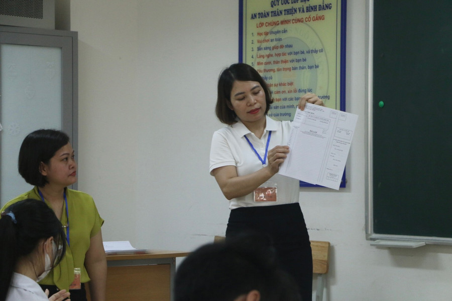 Giám thị phát giấy làm bài thi cho các thí sinh. Giám thị phát giấy làm bài thi cho các thí sinh.