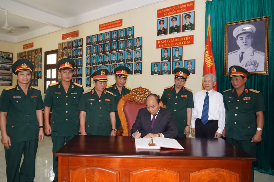 Thủ tướng ghi sổ lưu niệm tại Trường Sĩ quan Lục quân 2. Ảnh: VGP/Quang Hiếu