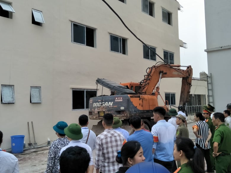 Lực lượng chức năng có mặt làm các thủ tục cưỡng chế phần vi phạm của công trình.