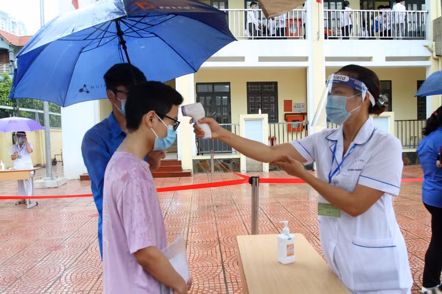 Đo thân nhiệt cho thí sinh trước khi vào phòng thi.