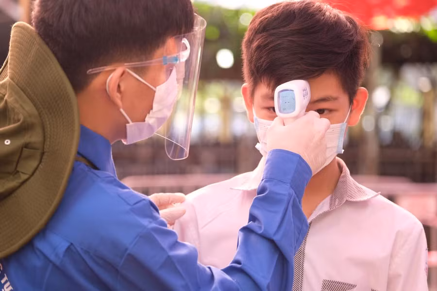 Thí sinh được đo thân nhiệt trước khi bước vào điểm thi