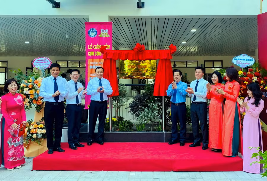 Các đại biểu thực hiện nghi thức gắn biển công trình tại Trường Tiểu học Kim Liên.