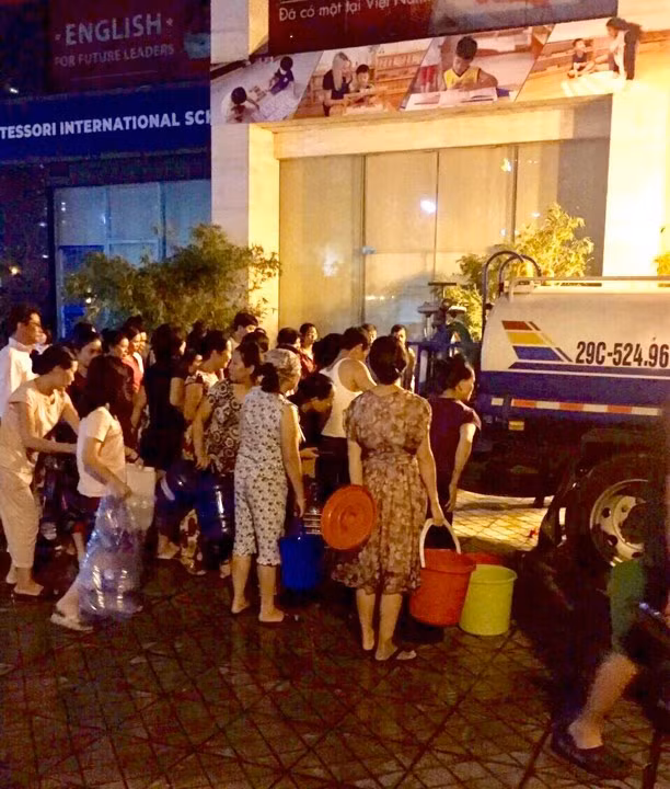 Người dân đợi lấy nước sạch từ Công ty Nước sạch Hà Nội đêm 15/10.