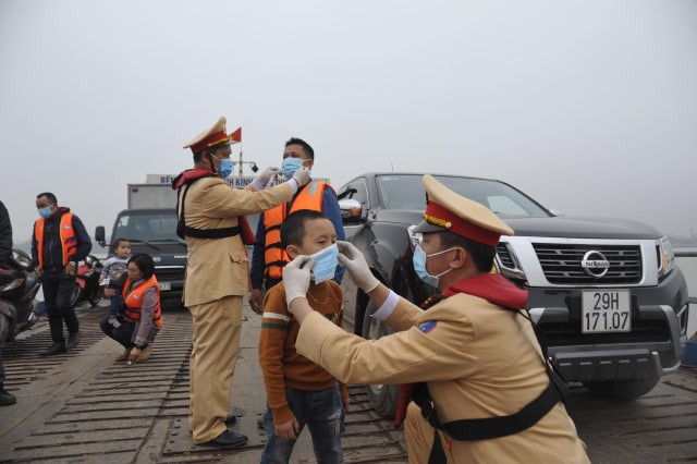 CSGT giúp cháu bé đeo khẩu trang.