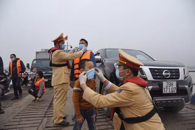 CSGT giúp cháu bé đeo khẩu trang.