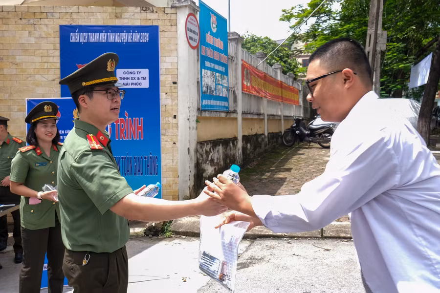Lực lượng công an tặng nước uống động viên thí sinh vững tin làm bài thi đạt kết quả cao.