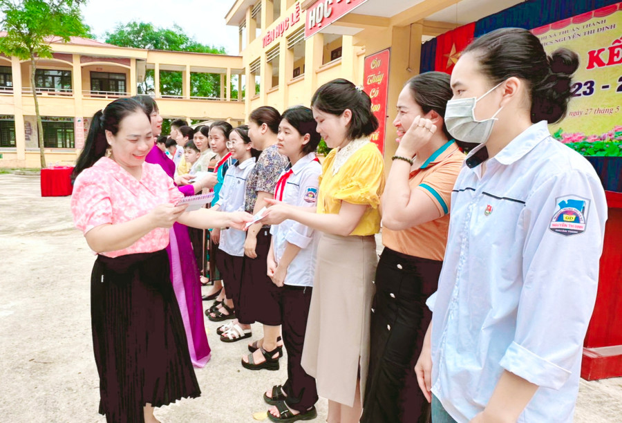 Cô giáo Nguyễn Thị Tươi (bên trái hàng đầu) trao khen thưởng cho giáo viên, học sinh nhà trường có nhiều thành tích.