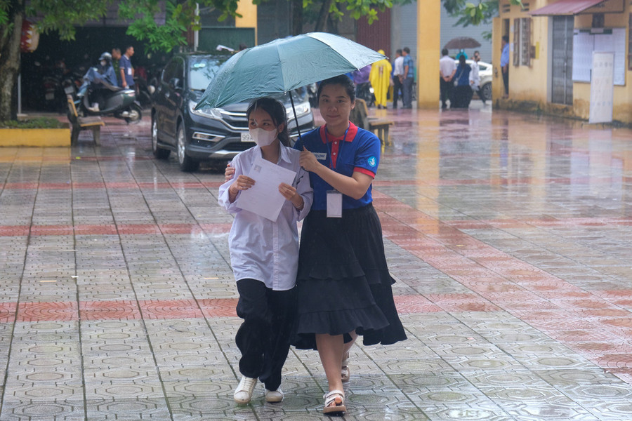 Hỗ trợ thí sinh dưới cơn mưa.