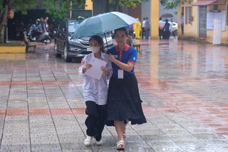 Hỗ trợ thí sinh dưới cơn mưa.