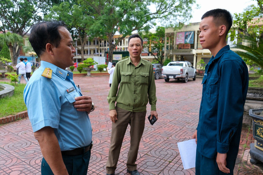 Ông Phú (giữa) động viên con trai vững tin bước vào kỳ thi. Ông Phú (giữa) động viên con trai vững tin bước vào kỳ thi.