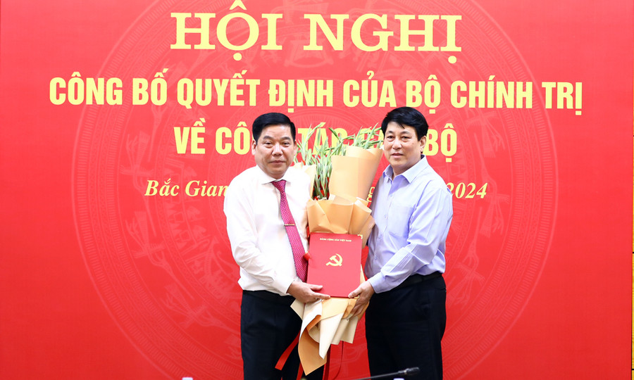 Thường trực Ban Bí thư Lương Cường (phải) trao quyết định và tặng hoa chúc mừng Trung tướng Nguyễn Văn Gấu. (Ảnh: BBG)