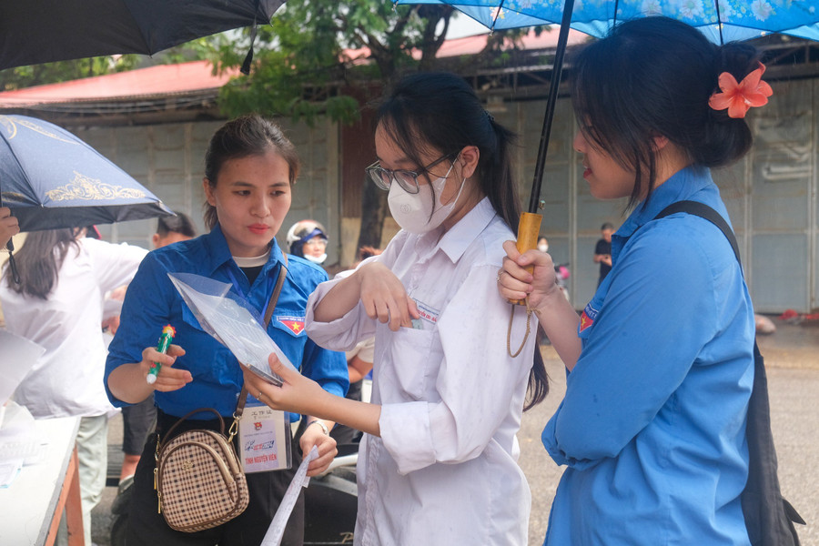 Cơn mưa khiến nhiều thí sinh bất ngờ nhưng được tình nguyện viên hỗ trợ kịp thời.