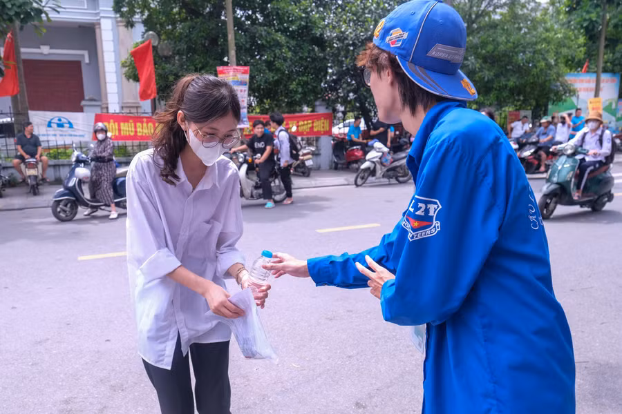 Thanh niên tình nguyện tặng nước uống, động viên thí sinh tự tin làm bài thi tốt.