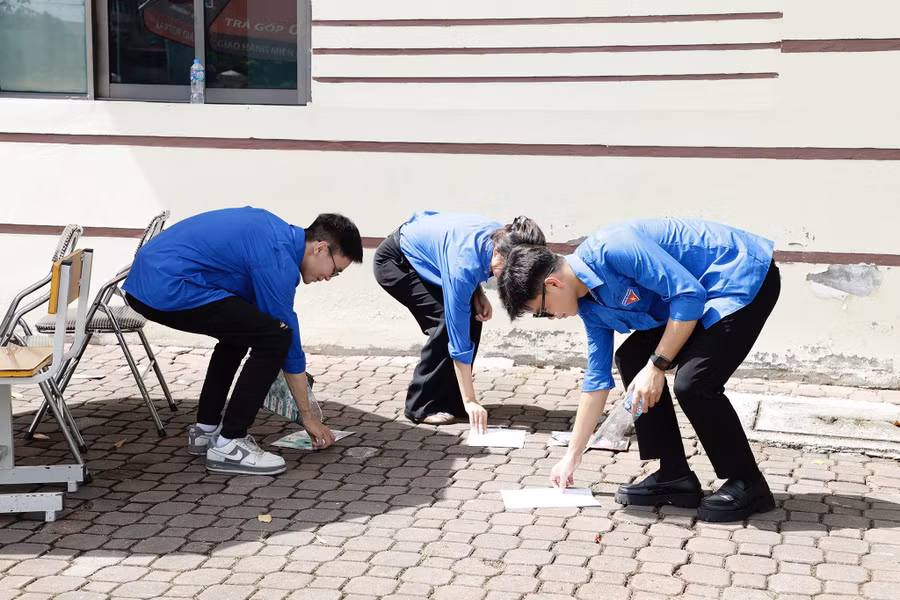 Hình ảnh tình nguyện viên dọn dẹp vệ sinh ở khu vực điểm thi.