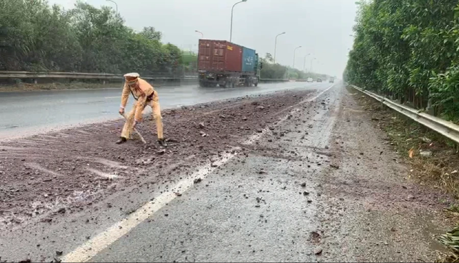 Chiến sĩ CSGT làm vệ sinh mặt đường để đảm bảo an toàn giao thông cho phương tiện qua lại.