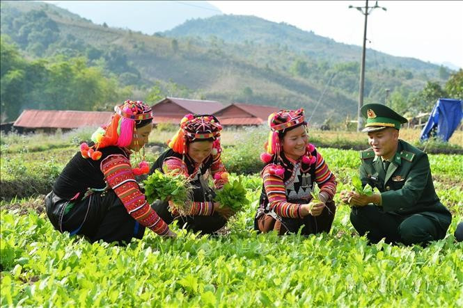 Cán bộ Đồn Biên phòng A Pa Chải (Điện Biên) giúp đỡ người dân phát triển kinh tế, xóa đói, giảm nghèo, góp phần xây dựng nông thôn mới, củng cố mối quan hệ đoàn kết, gắn bó quân dân. Ảnh: Minh Đức/TTXVN