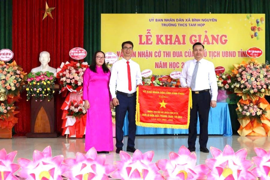 Ông Nguyễn Mạnh Hùng – Tỉnh ủy viên, Bí thư Đảng ủy, Chủ tịch HĐND xã Bình Nguyên (bên phải) trao Cờ thi đua của UBND tỉnh Vĩnh Phúc tặng Trường THCS Tam Hợp đơn vị dẫn đầu phong trào thi đua năm học 2024 - 2025.