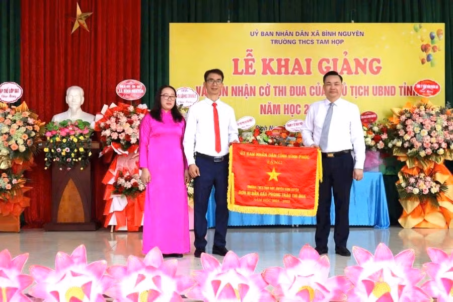 Ông Nguyễn Mạnh Hùng – Tỉnh ủy viên, Bí thư Đảng ủy, Chủ tịch HĐND xã Bình Nguyên (bên phải) trao Cờ thi đua của UBND tỉnh Vĩnh Phúc tặng Trường THCS Tam Hợp đơn vị dẫn đầu phong trào thi đua năm học 2024 - 2025.