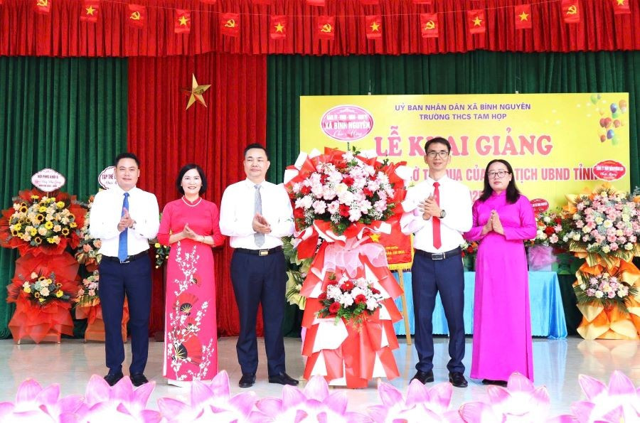 តំណាងថ្នាក់ដឹកនាំឃុំ Binh Nguyen (ឆ្វេង) ជូនកម្រងផ្កាអបអរសាទរលោកគ្រូ អ្នកគ្រូ និងសិស្សានុសិស្សនៃអនុវិទ្យាល័យ Tam Hop។ z7010488327637-b904e0e3403567bd10a3d08e9b5f1c68.jpg
