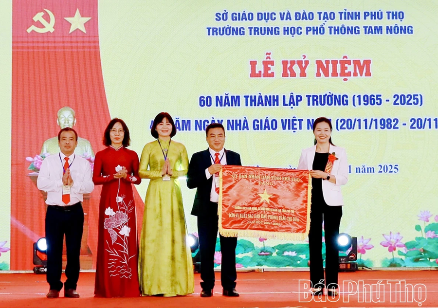 Bà Bùi Thị Minh - Phó Bí thư Tỉnh ủy Phú Thọ trao Cờ thi đua của UBND tỉnh Phú Thọ cho nhà trường (ảnh Báo Phú Thọ).