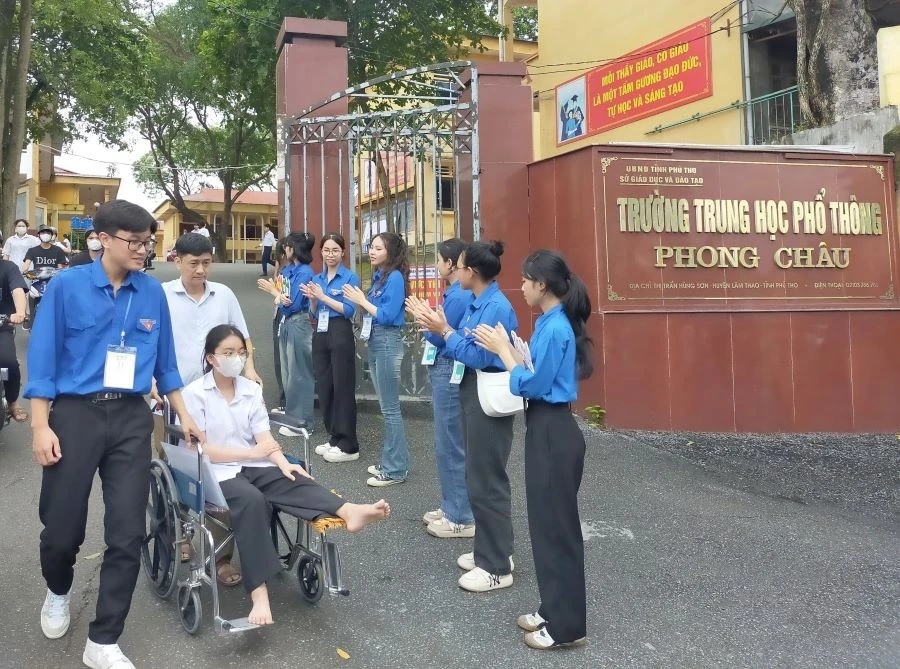 Thanh niên tình nguyện hỗ trợ thí sinh di chuyển ở Kỳ thi tốt nghiệp THPT năm 2024 tại điểm thi Trường THPT Phong Châu, huyện Lâm Thao.