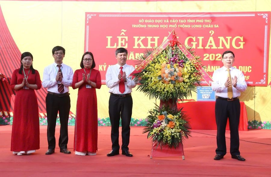 Ông Bùi Huy Vĩnh - Phó Bí thư Tỉnh ủy Phú Thọ (thứ nhất bên phải) tặng hoa chúc mừng thầy và trò trường THPT Long Châu Sa.