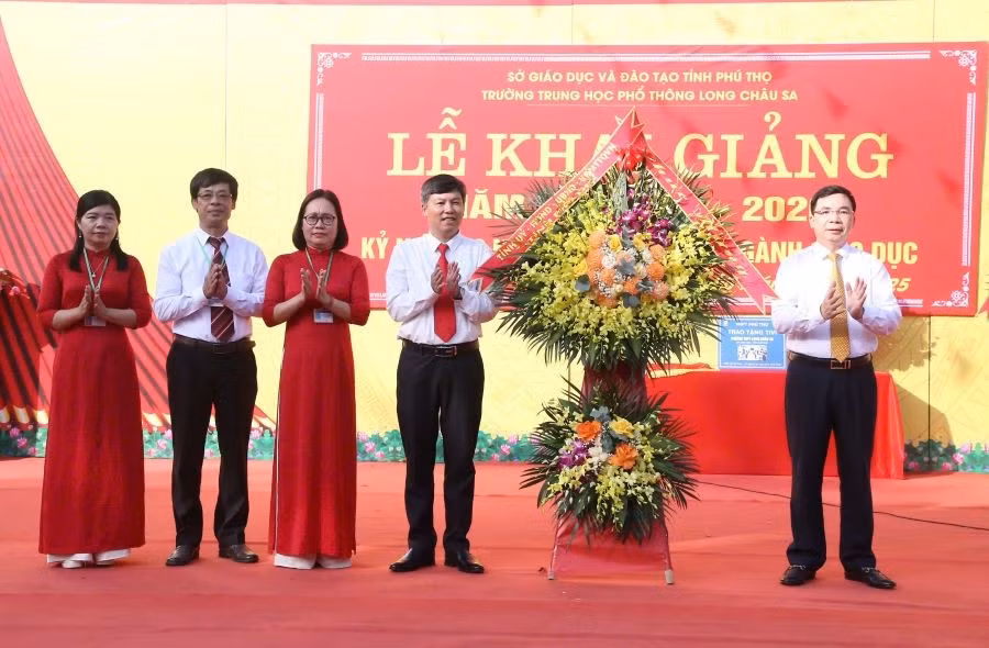 Ông Bùi Huy Vĩnh - Phó Bí thư Tỉnh ủy Phú Thọ (thứ nhất bên phải) tặng hoa chúc mừng thầy và trò trường THPT Long Châu Sa.