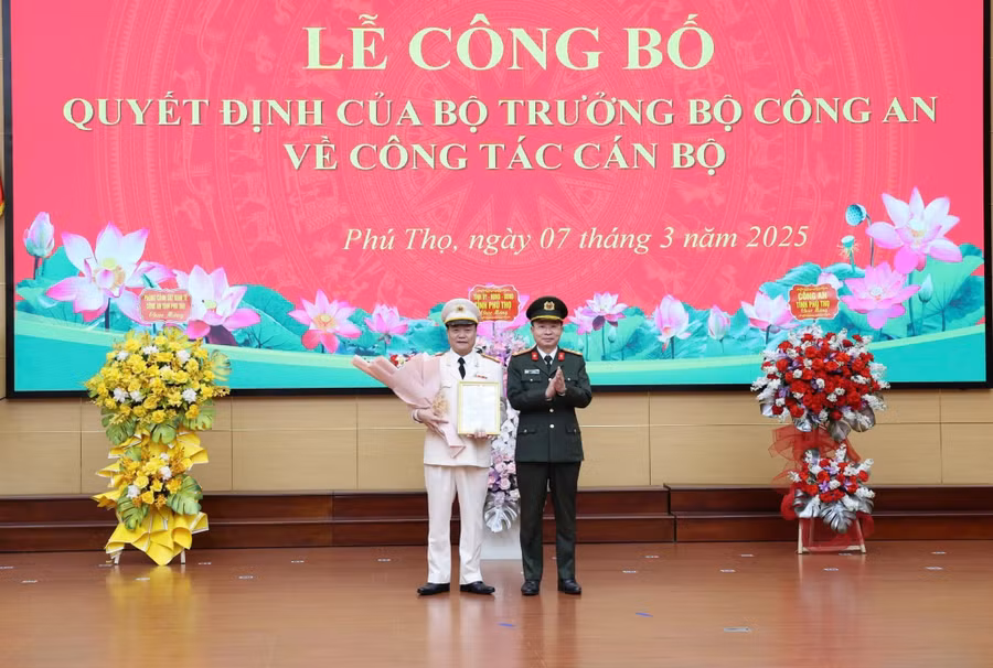 Đại tá Nguyễn Minh Tuấn, Giám đốc Công an tỉnh Phú Thọ trao Quyết định và tặng hoa chúc mừng tân Phó Giám đốc Công an tỉnh Phú Thọ - Thượng tá Bùi Quang Khoa (bên trái).