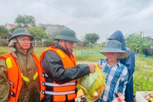 Thượng tướng Trương Thiên Tô, Phó Chủ nhiệm Tổng cục Chính trị Quân đội nhân dân Việt Nam trao hỗ trợ nhu yếu phẩm cho nhân dân vùng lũ. 