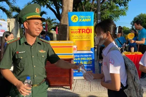Thượng úy Phạm Trọng Sơn trao nước cho các thí sinh mang vào phòng thi sử dụng.