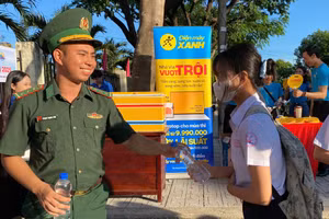 Thượng úy Phạm Trọng Sơn trao nước cho các thí sinh mang vào phòng thi sử dụng.
