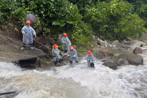 Lực lượng chức năng căng dây đưa thi thể nạn nhân lên bờ. 
