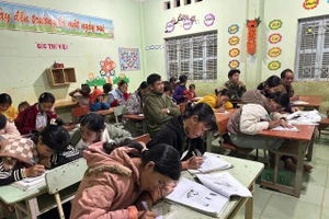 Các học viên lớp học xóa mù chữ chăm chú viết bài.