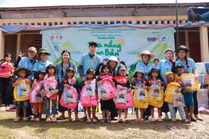 Trao cặp sách cho học sinh vùng cao.