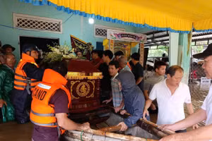 Lực lượng Bộ đội hỗ trợ đưa linh cữu cụ bà T. đi an táng trong điều kiện nước lũ ngập sâu.