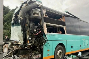 Phần đầu xe khách 50H-302.xx bị hư hỏng nặng sau cú va chạm, nhiều mảnh vỡ kính lái rơi vãi trên mặt đường.