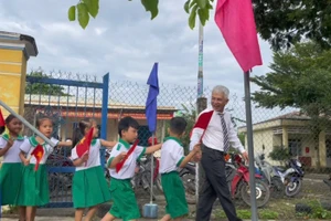 Ông Trần Bảo Tú - Hiệu trưởng Trường Tiểu học Nguyễn Bá Ngọc dắt học sinh lớp 1 vào trường.