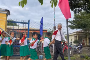 Ông Trần Bảo Tú - Hiệu trưởng Trường Tiểu học Nguyễn Bá Ngọc dắt học sinh lớp 1 vào trường.